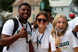 three smiling students in white t-shirts from welcome weekend
