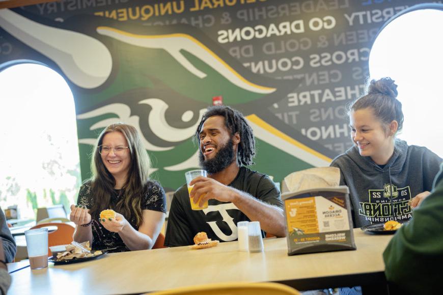 Group of students smiling in the dining hall